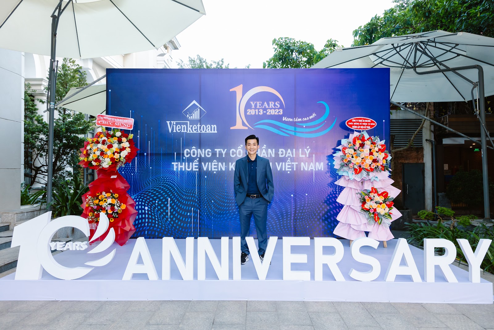 Robert Nguyễn Huy tại backdrop lễ kỷ niệm 10 năm Viện Kế Toán 2013–2023